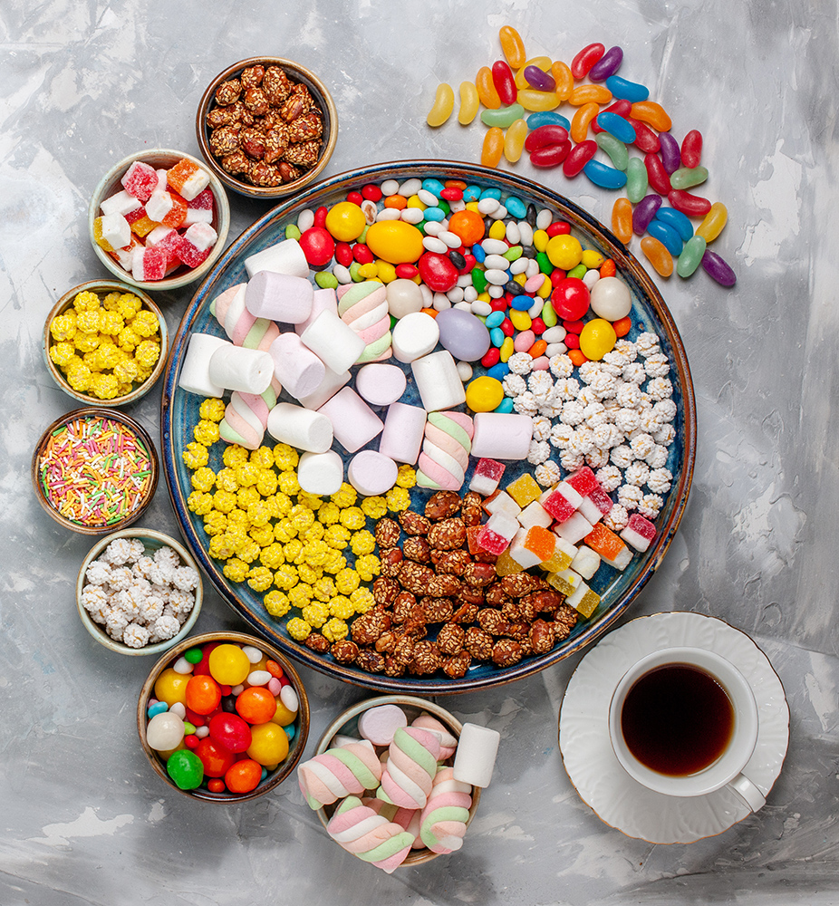 top view candy composition different colored candies with marshmallow and tea on white desk sugar candy bonbon sweet confitures